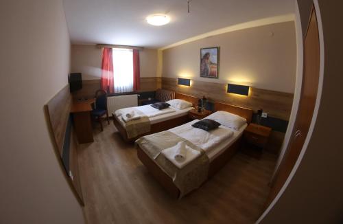 a hotel room with two beds and a mirror at Hotel Zagi in Oroslavje