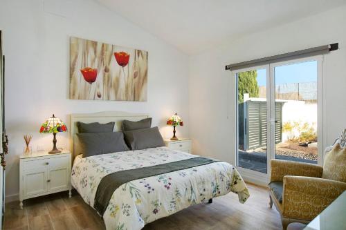 een slaapkamer met een bed, een stoel en een raam bij Los Cipreses in Ingenio