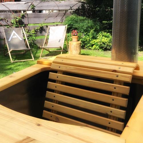a wooden deck with a table and a chair at Gasthof Auwirt in Sankt Michael im Lungau