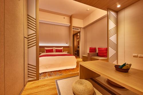 a bedroom with a bed and a mirror at Uni-Resort Ku-Kuan in Heping