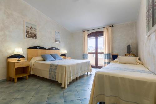 a bedroom with two beds and a window at Hotel Villa del Mare Solanas in Solanas