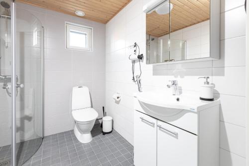 a white bathroom with a toilet and a sink at Valoisa parvekkeellinen kaksio, oma parkkipaikka in Tampere