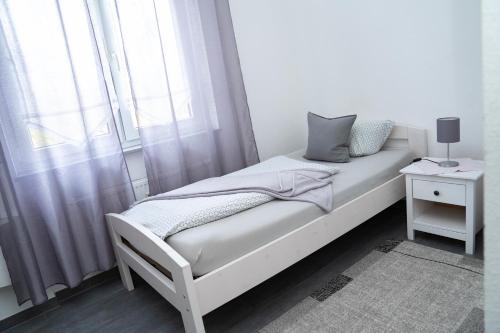 um quarto branco com uma cama e uma janela em Hotel Schenk em Pirmasens