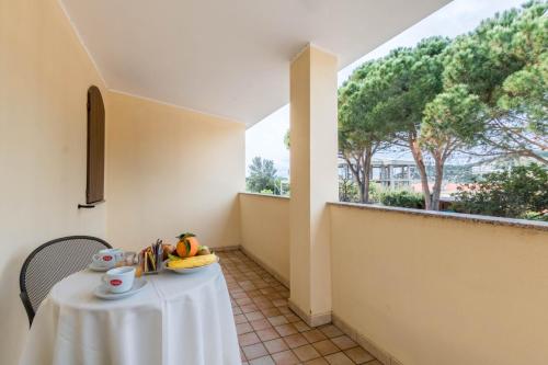 a white table with a bowl of fruit on it at Hotel Villa del Mare Solanas in Solanas