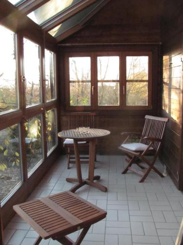 a screened in porch with a table and two chairs at Hochwertiges Ferienhaus im romantischen Franken in Colmberg