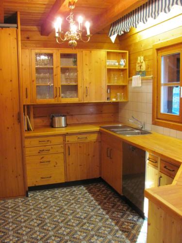 a large kitchen with wooden cabinets and a chandelier at Hochwertiges Ferienhaus im romantischen Franken in Colmberg