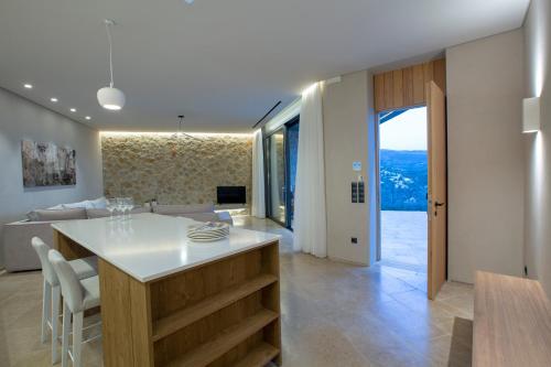 a kitchen and living room with a table and a couch at Blooms of Sivota Bay - Luxury villas with private heated pool in Sivota