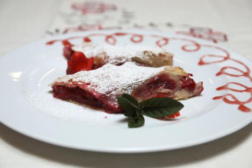 a white plate with a piece of cake with strawberries at Hotel Zagi in Oroslavje