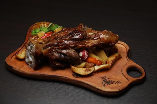 a plate of meat and vegetables on a cutting board at Hotel Zagi in Oroslavje