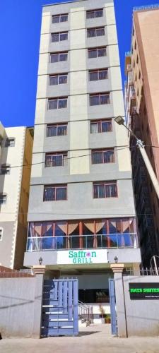 a tall white building with a sign in front of it at Hays Suites Hotel in Nairobi