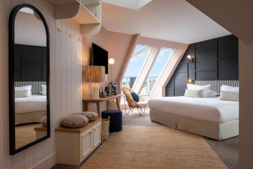 a hotel room with two beds and a mirror at Le Celtique & Spa in Carnac