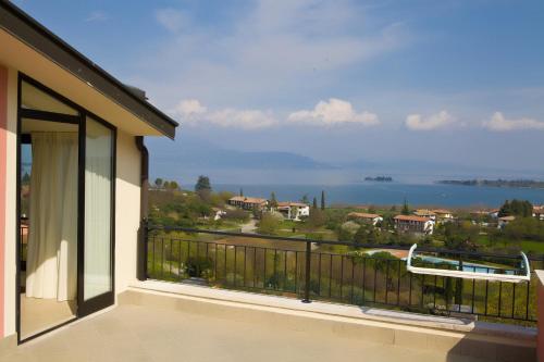 a balcony of a house with a view of the water at Hotel Belvedere in Manerba del Garda