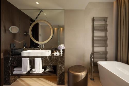 a bathroom with a sink and a tub and a mirror at InterContinental - Ljubljana, an IHG Hotel in Ljubljana