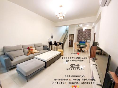 a living room with a couch and a table at 辰瑄星辰包棟民宿-Star Sky烤肉ktv看星星包棟民宿 in Wujie