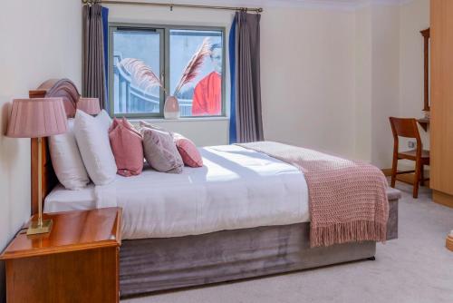 a bedroom with a bed with a window and a table at Park Place Apartments in Killarney