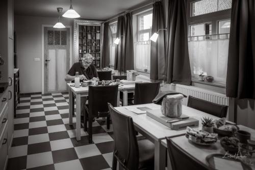 a man sitting at a table in a dining room at B&B Stefans Pottery in Poperinge