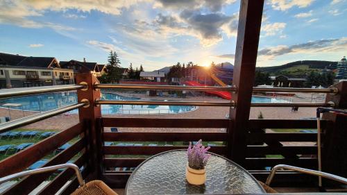een tafel op een balkon met uitzicht op een zwembad bij Apartmán AQUAPARK - Hotel Bešeňová in Bešeňová