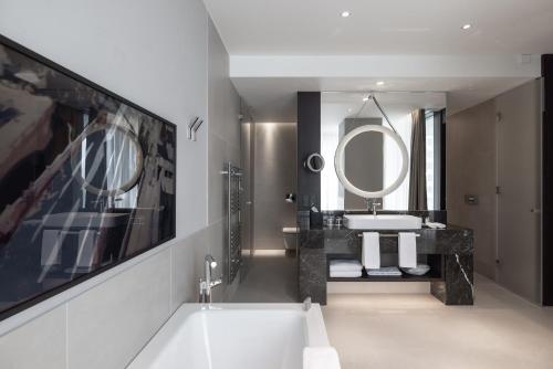 a bathroom with a sink and a large mirror at InterContinental - Ljubljana by IHG in Ljubljana