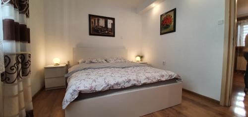 a bedroom with a bed with two lamps on it at Apartament Kaduk in Nowy Sącz