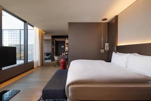 a bedroom with a large bed and a large window at InterContinental - Ljubljana by IHG in Ljubljana