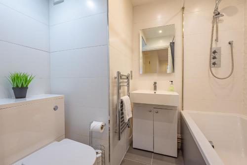 a bathroom with a toilet and a sink and a shower at Cozy 2 Bedroom Apartment in Newbury Town Centre - SLEEPS 7 with NETFLIX and WiFi in Newbury