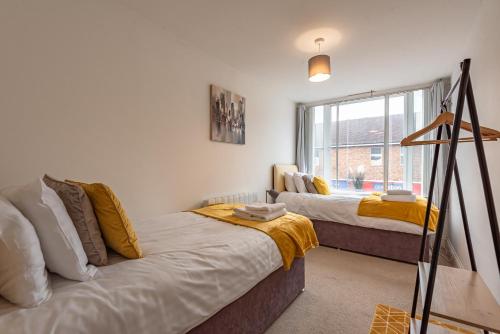 a bedroom with two beds and a window at Cozy 2 Bedroom Apartment in Newbury Town Centre - SLEEPS 7 with NETFLIX and WiFi in Newbury