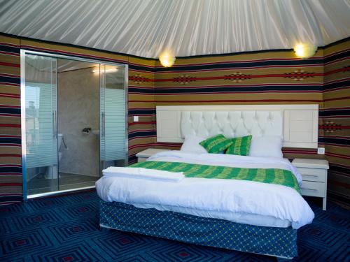 a bedroom with a large bed and a shower at The Rock Camp Petra in Wadi Musa