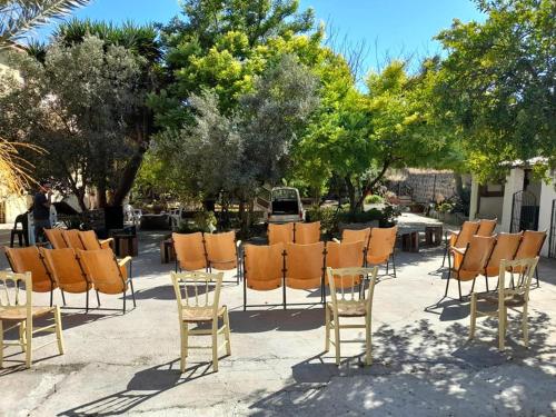 eine Gruppe orangefarbener Stühle, Tische und Bäume in der Unterkunft Domu Odilia in Serrenti