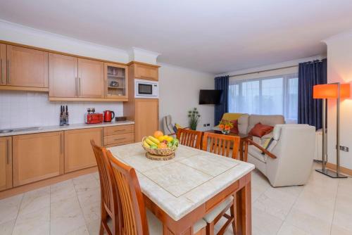 a kitchen with a table with a bowl of fruit on it at Park Place Apartments in Killarney