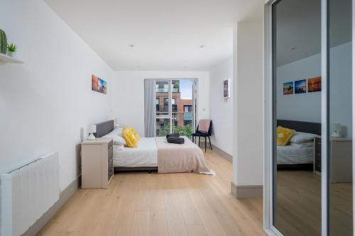 um quarto com uma cama e uma porta de vidro deslizante em Regents North London Apartments em Londres