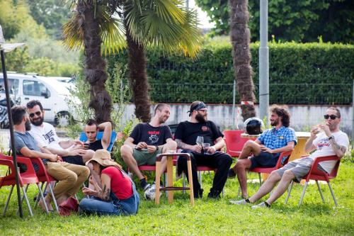 a group of people sitting in chairs in the grass at Ostello La Salana in Capannori
