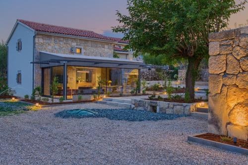 a home with a stone house with a yard at Luxury Jerini Barn in Krk