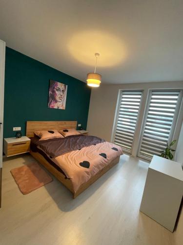 a bedroom with a bed and a green wall at Apartament Bella in Târgu-Mureş