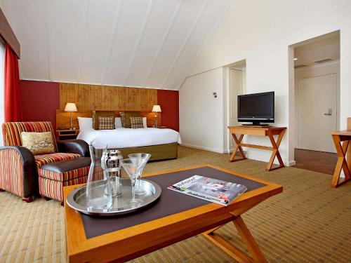 Fairmont Resort & Spa Blue Mountains MGallery by Sofitel في ليورا: غرفة بالفندق بها سرير وطاولة قهوة