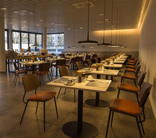 Best Western soibelmanns Frankfurt Airport في غروس غيراو: صف من الطاولات والكراسي في المطعم