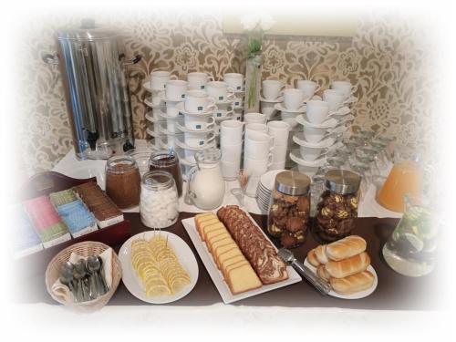 a table topped with plates of pastries and containers of food at Hotel TiM in Cekanowo