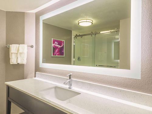 a bathroom with a sink and a large mirror at La Quinta by Wyndham Austin at The Domain in Austin