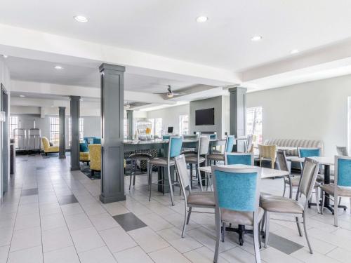 a dining room with chairs and tables and a bar at La Quinta by Wyndham Kansas City Airport in Kansas City
