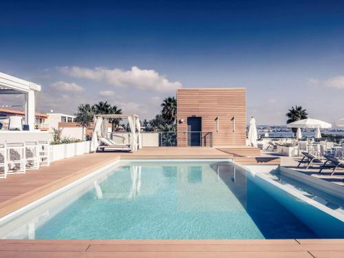 a swimming pool on the roof of a house at Mercure Villeneuve Loubet Plage in Villeneuve-Loubet