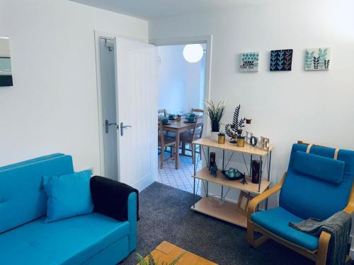 uma sala de estar com duas cadeiras azuis e uma mesa em Cosy Family Home - Coventry City Centre - Entire House em Coventry