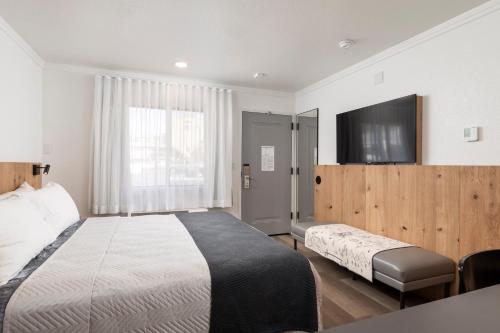 a hotel room with two beds and a flat screen tv at Hotel Lumberjack - Sonora in Sonora