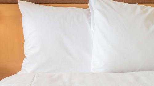 a white pillow sitting on top of a bed at Sonesta Simply Suites Philadelphia Mount Laurel in Mount Laurel