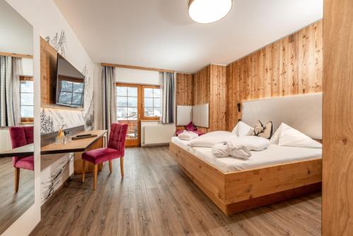 Habitación de hotel con cama, escritorio y escritorio. en Felsners Hotel & Restaurant, en Haus im Ennstal