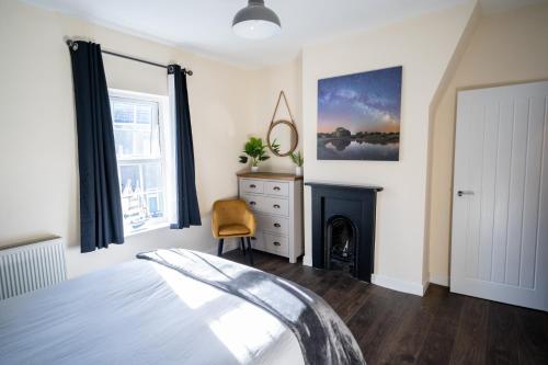 1 dormitorio con 1 cama y chimenea en Sunrise Beach House en Cleethorpes