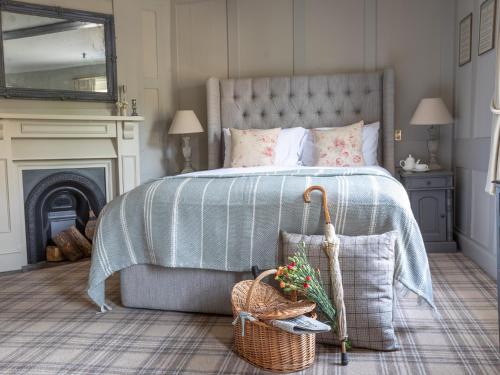 a bedroom with a bed with a blue blanket and a basket at The Running Horses in Mickleham
