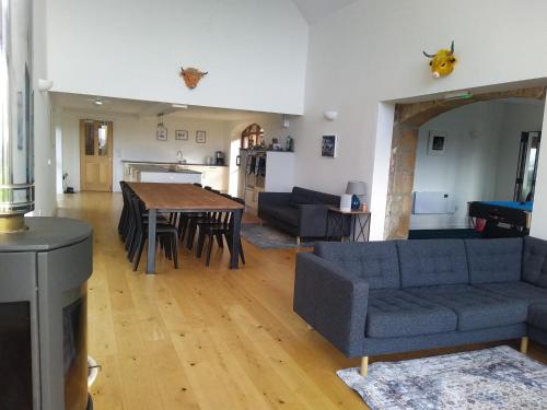 a living room with a couch and a table at Balloan Steading West in Dornoch