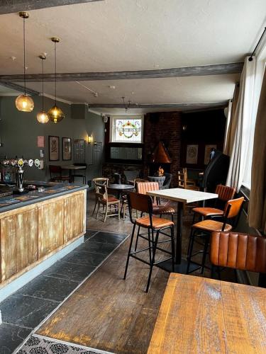 a restaurant with tables and chairs and a bar at The White Hart in Whitchurch