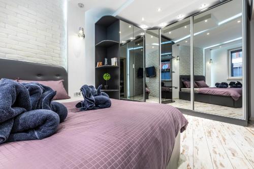 a bedroom with a purple bed with a large mirror at Modern 1BD Flat with a Parking near the city centre in Plovdiv