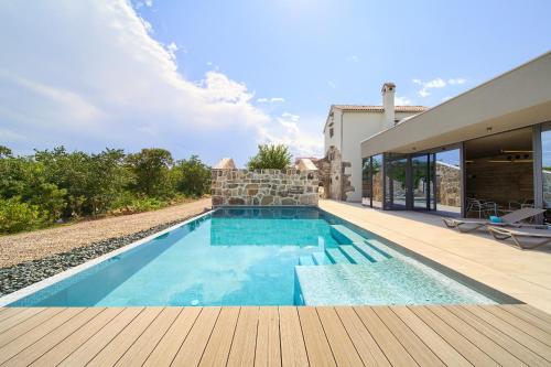 a swimming pool in the backyard of a house at Luxury Jerini House with pool and wellness in Bajčići