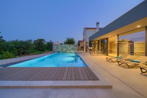 a swimming pool on the side of a building at Luxury Jerini House with pool and wellness in Bajčići